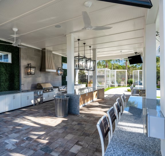 a large outdoor kitchen with a long table and chairs at Drift, Daytona Beach, FL, 32117