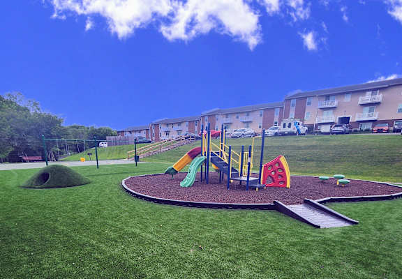a playground in a park in front of an apartment building