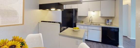 A kitchen with a refrigerator, oven, and dishwasher.