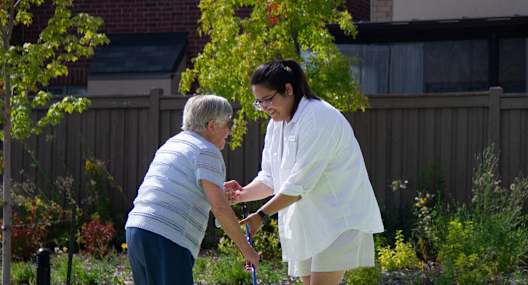 a woman is helping an older woman play golf on a court