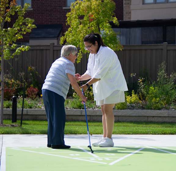 a woman is helping an older woman play golf on a court