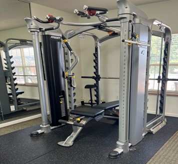 A gym with a black and silver weight machine.