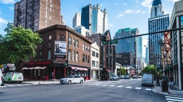a city street with cars and tall buildings