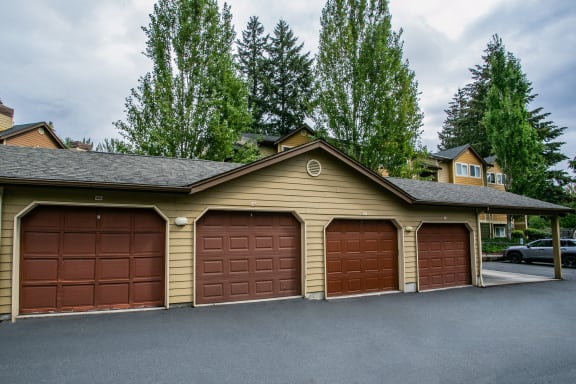 a garage with three garage doors on the side of a house