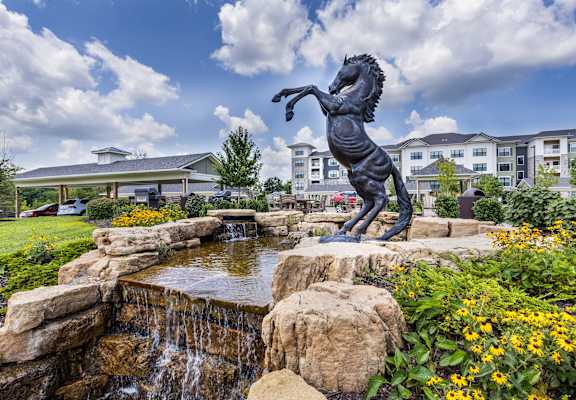 a statue of a horse standing on its hind legs next to a fountain at Aventura at Wild Horse Creek, Chesterfield, 63017