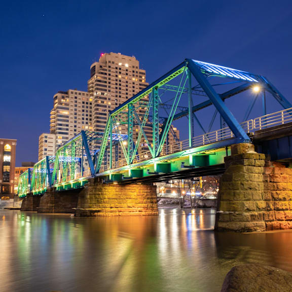 A bridge with a blue structure and lights on it.