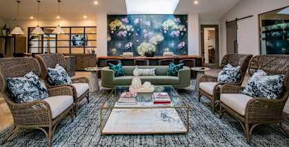 a living room with couches and chairs and a large painting on the wall