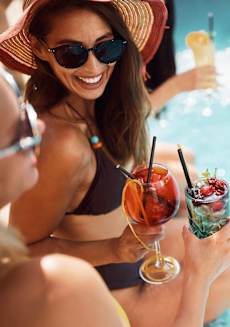 two women drinking cocktails by the swimming pool at Hidden Creek, Gaithersburg