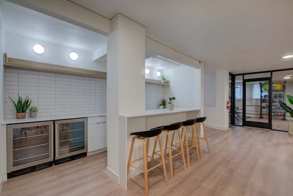  A kitchen with a bar area and wooden floors.