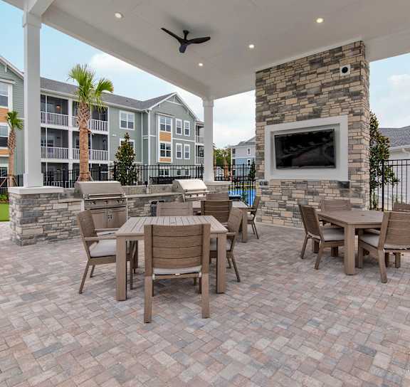 A patio with a table and chairs and a fireplace.