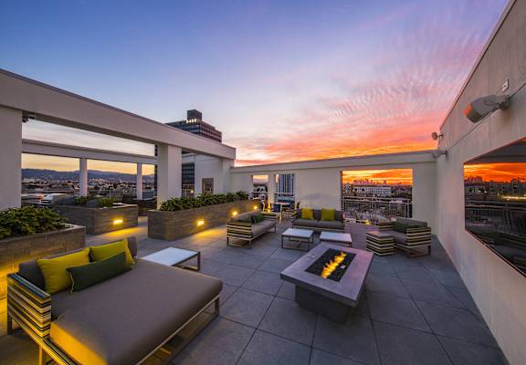 A rooftop patio with a fire pit and seating area.