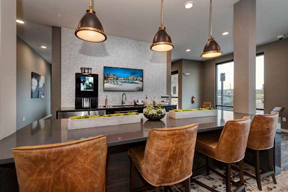 a large kitchen with a bar and chairs and a television at Watermark on Twenty Mile, Parker, 80134