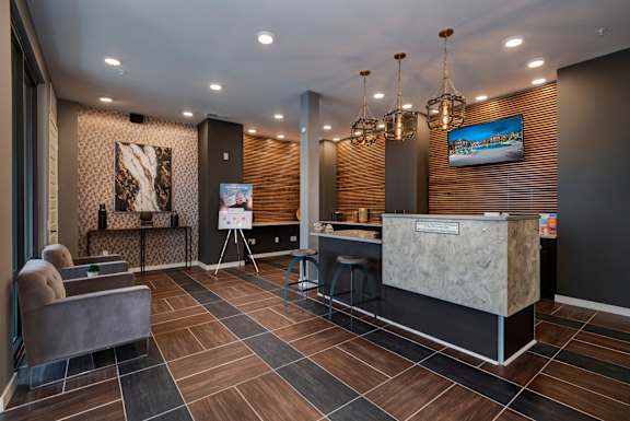 a lobby with a reception desk and a tv at Watermark on Twenty Mile, Parker, 80134