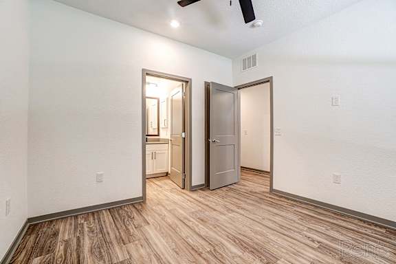 A room with a wooden floor and a ceiling fan.