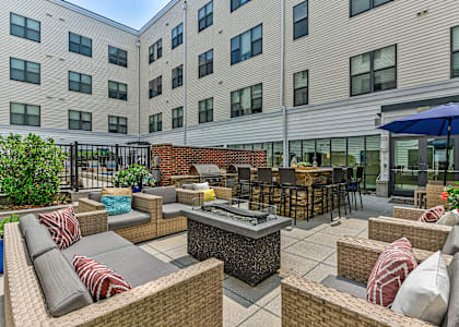 a patio with furniture and an umbrella in front of an apartment building at The View at Old City, Philadelphia