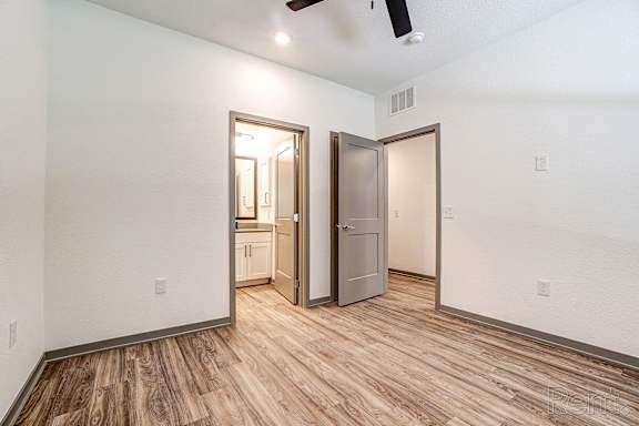 A room with a wooden floor and a ceiling fan.