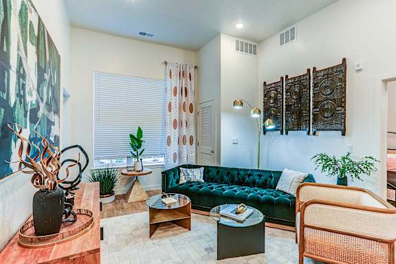 A living room with a green sofa and a wooden table.