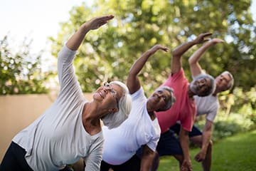 a group of people doing yoga in the park