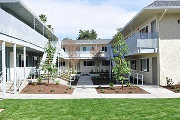 an exterior view of a building with a lawn and trees