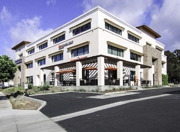 a large white building with a street in front of it
