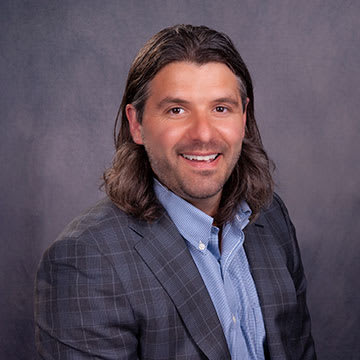 a man with long hair and a shirt and a suit