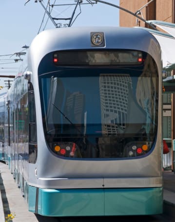 a blue and silver train parked at a train station
