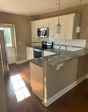 A kitchen with a granite countertop and white cabinets.