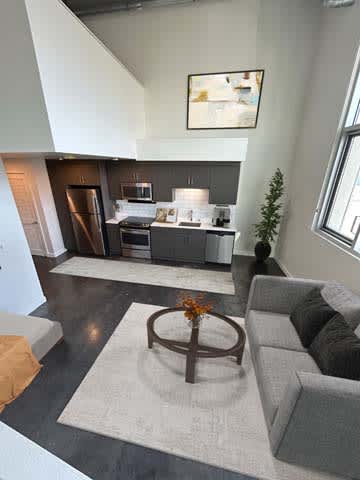 A modern living room with a grey couch and a coffee table.