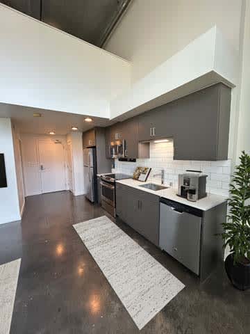 A modern kitchen with a large island and stainless steel appliances.