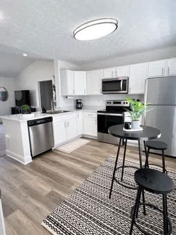 A kitchen with a black and white rug on the floor.
