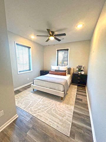 A bedroom with a bed, nightstand, and a ceiling fan.