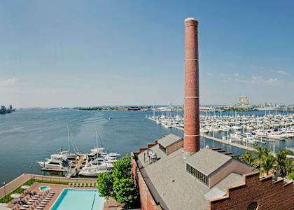 a view of the harbor from a building with a pool and boats in the waterat Tindeco Wharf, Baltimore Maryland