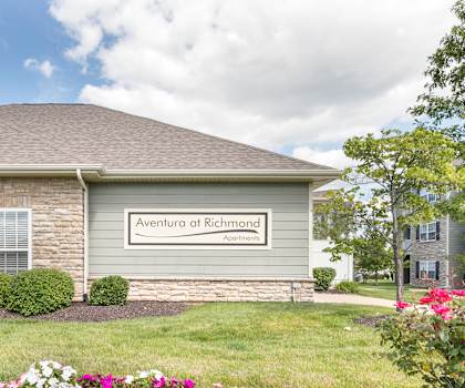 a building with pillars and a sign in front of it  at Aventura at Richmond, St. Peters, MO
