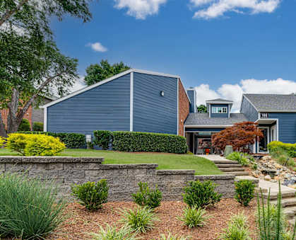 a blue house with a landscaped yard and stairs