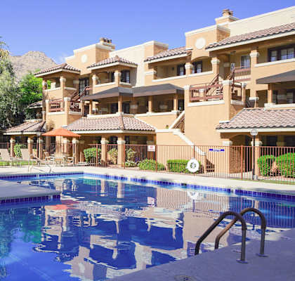 A large swimming pool in front of apartment buildings.