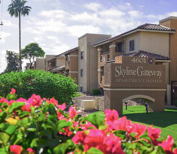 The image shows a beautiful view of the Skyline Gateway Apartment Homes entrance with a sign that reads "4601 Skyline Gateway Apartment Homes".