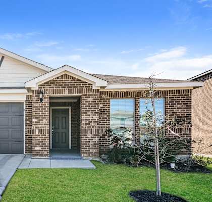 A house with a brick facade and a grey garage door.
