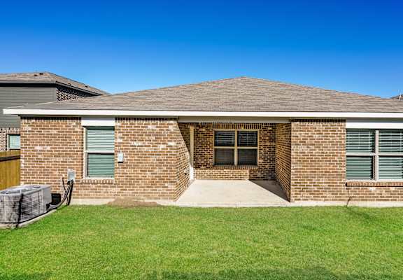 A house with a brick facade and a covered patio.