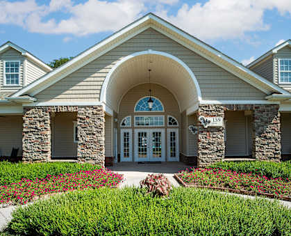 A building with a stone archway entrance and a landscaped front yard.