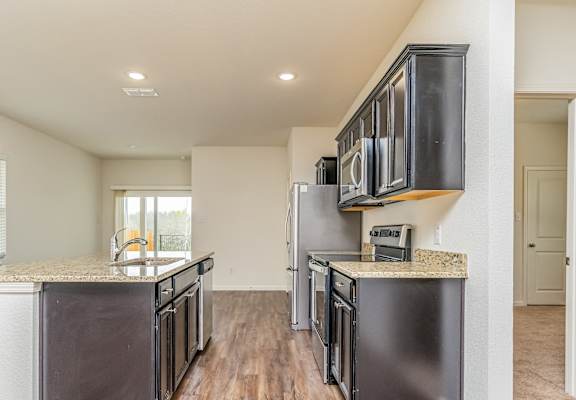 an open kitchen with stainless steel appliances and a counter top