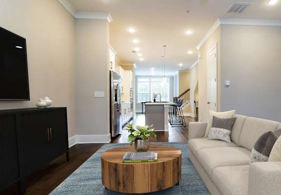 A living room with a white couch and a wooden coffee table.