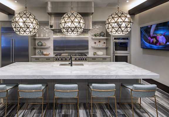 a kitchen with a large marble counter top and chairs