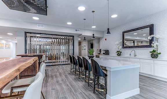 A modern kitchen with a bar area and a dining table.