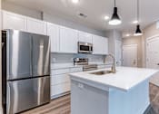 Thumbnail 5 of 31 - A modern kitchen with a stainless steel refrigerator and white cabinets.at Tiffany Flats, Columbus, 43231