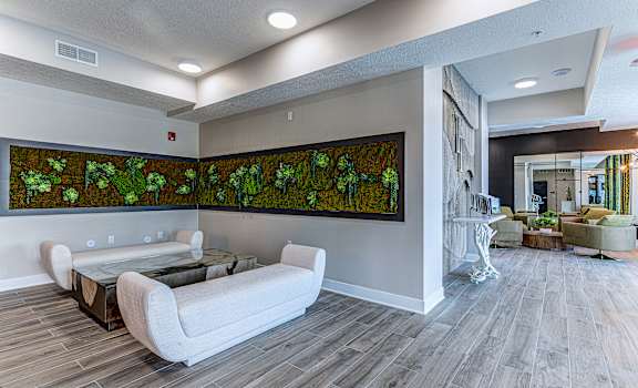 A living room with a large painting of green plants on the wall.at Tiffany Flats, Columbus, Ohio