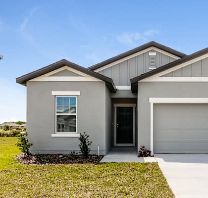 A two-story house with a garage door and a window.