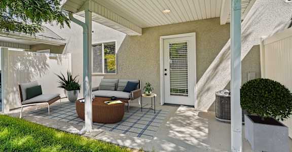a patio with a couch and chairs and a white door