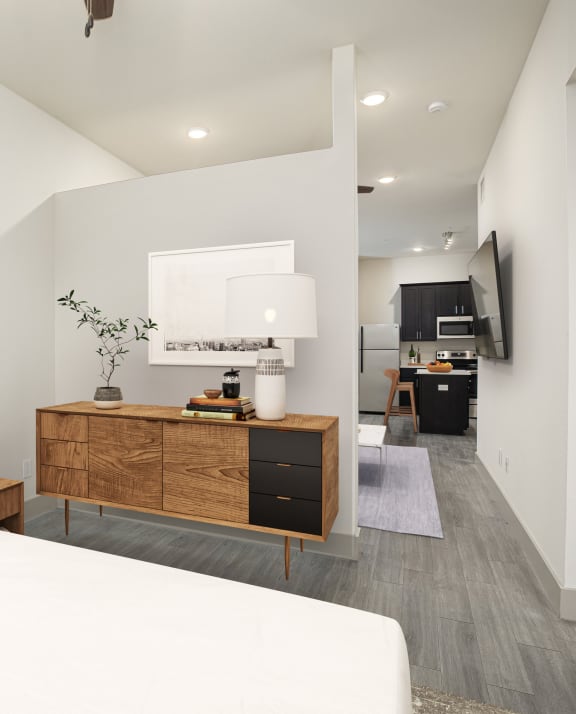 a bedroom with a white bed and a wooden dresser