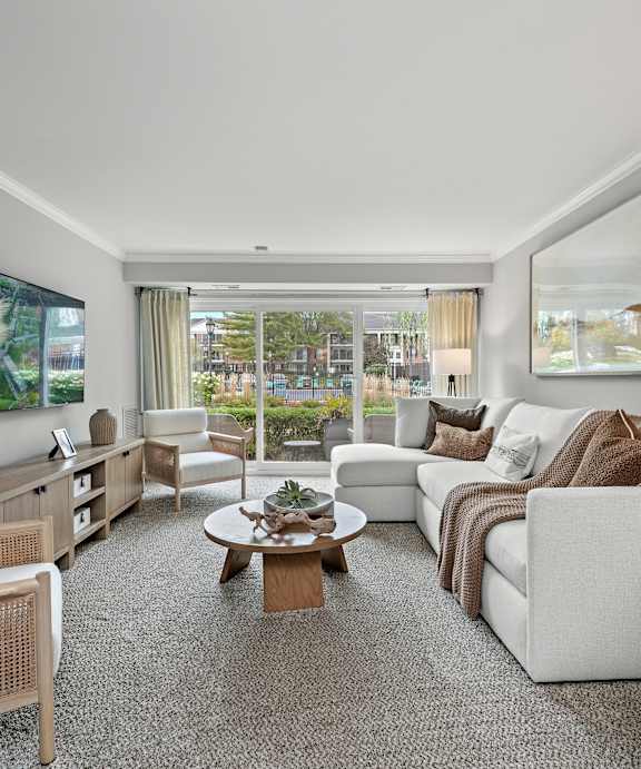 A well-lit, spacious living room with a variety of seating options and a coffee table.