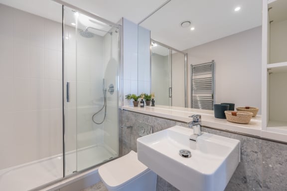 a bathroom with a sink and a shower and a toilet